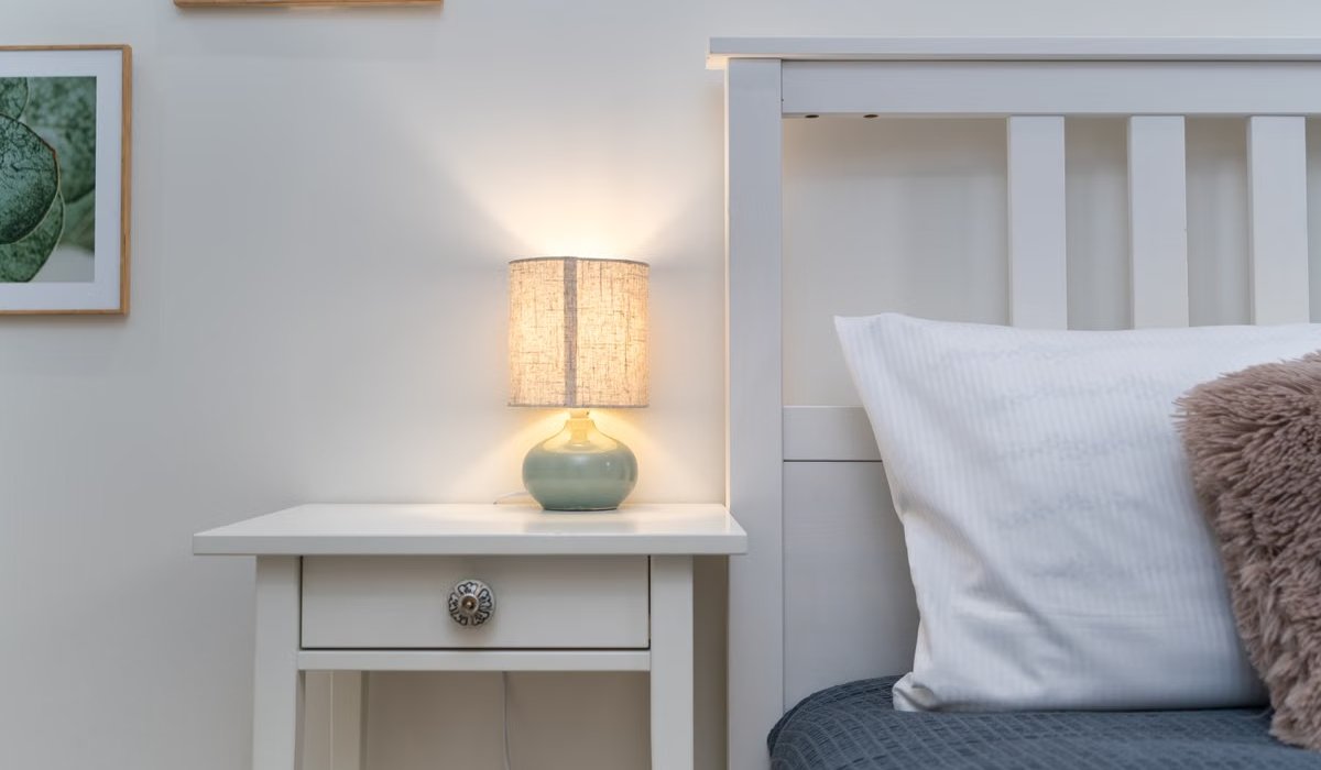 Warm bedside lamp glowing in a cozy bedroom at night