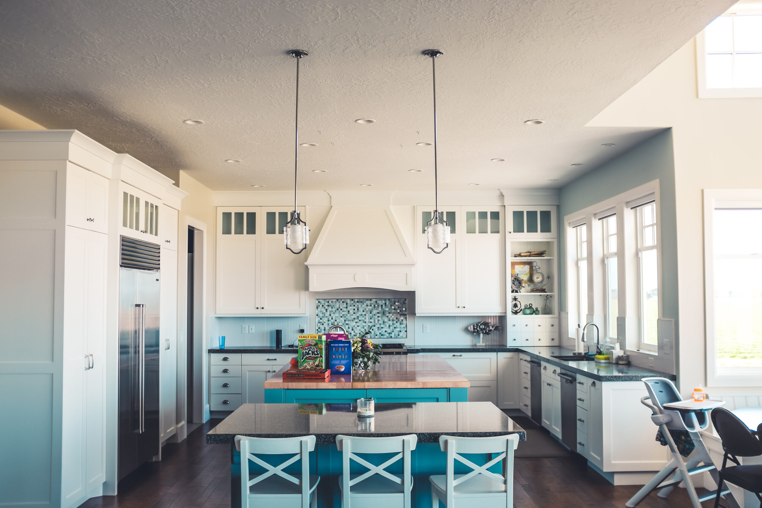 Bright blue and white modern kitchen interior filled with natural light