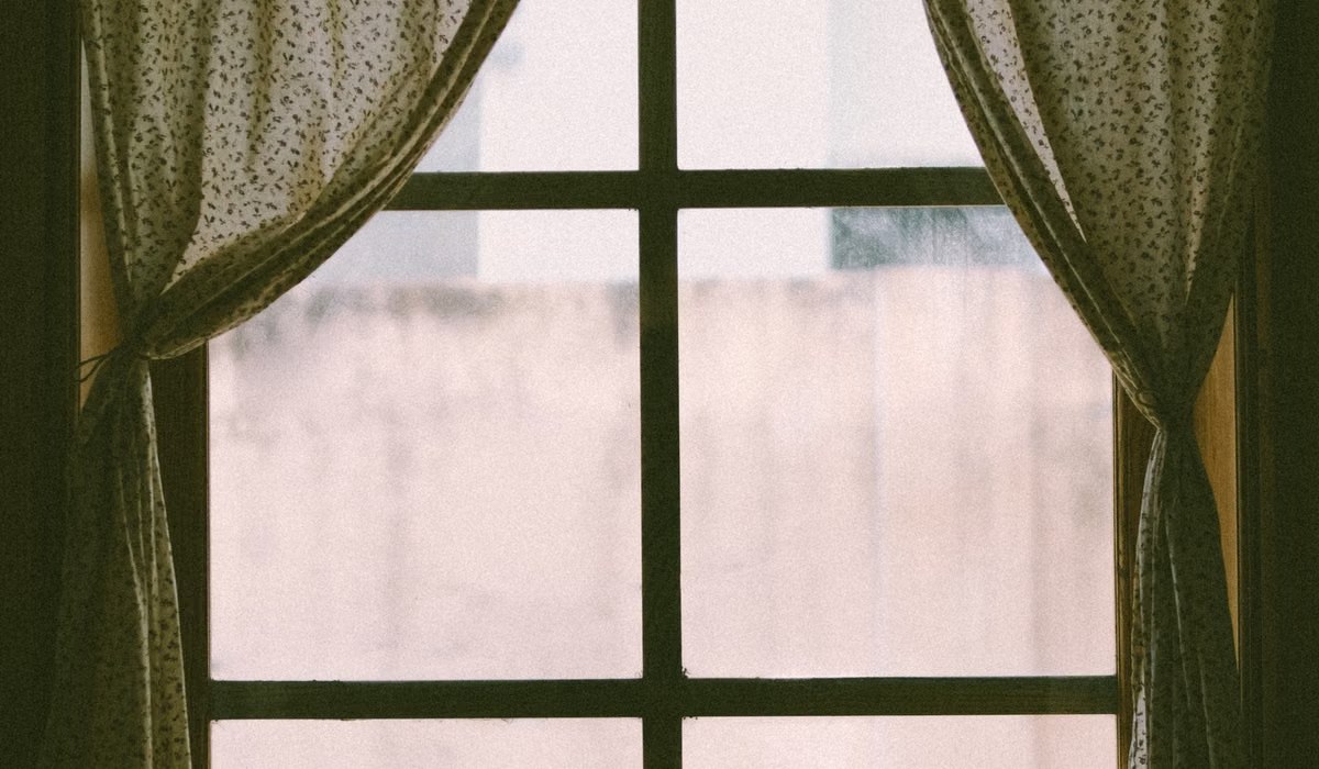 Living room window with curtains hung on a simple rod
