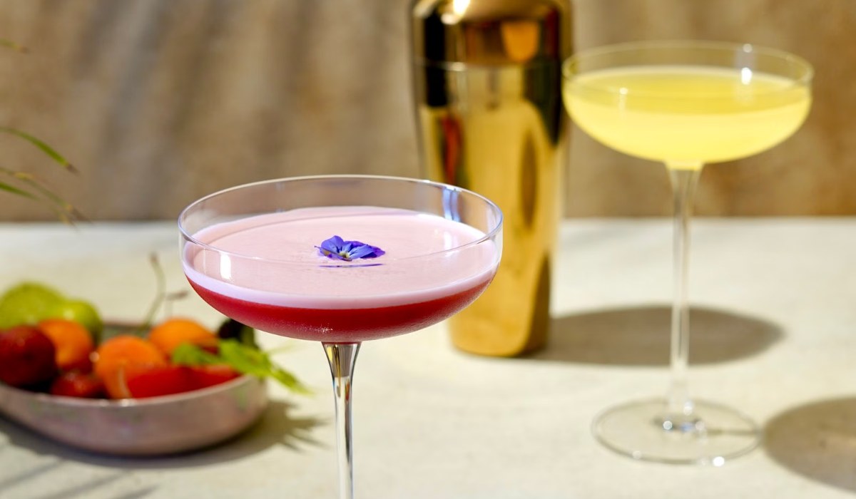 Coupe cocktails poured and resting on a home bar surface