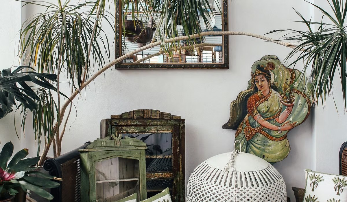 Bohemian living room corner with houseplants, patterned cushions and layered decor