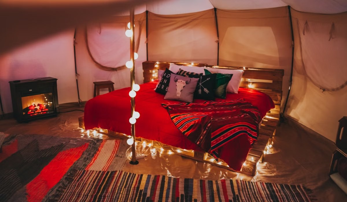 Warm string lights glowing across a bed at night