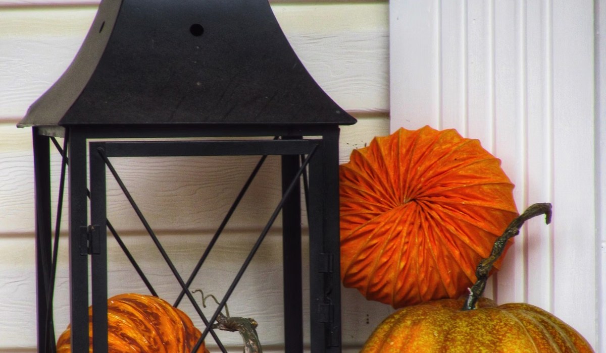 Black lantern and pumpkins styled on a fall porch