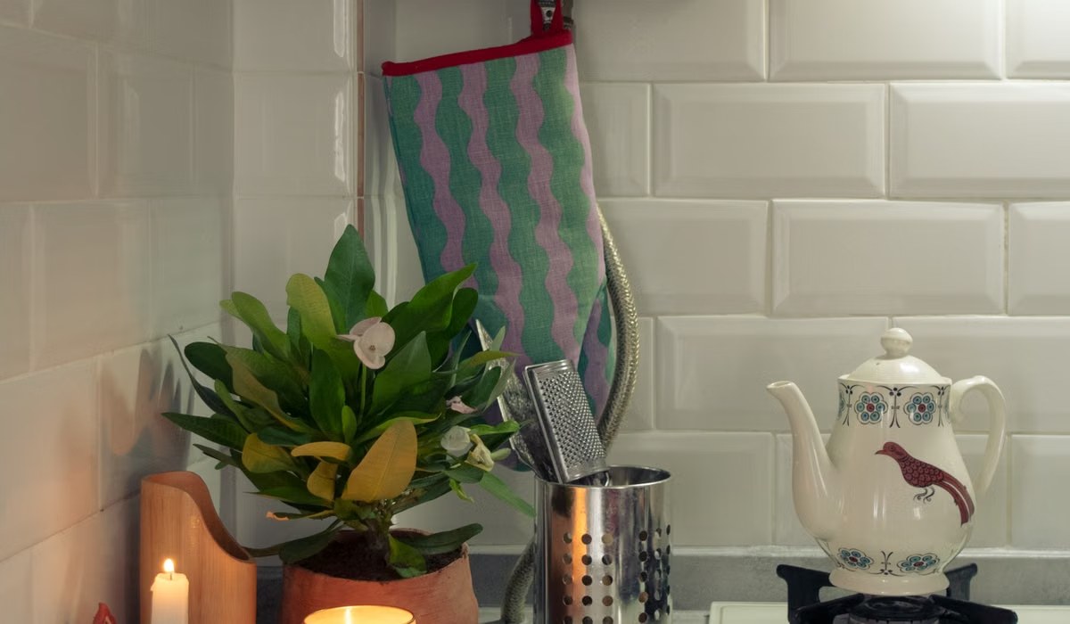 Warm kitchen counter with teapot, candles and a plant