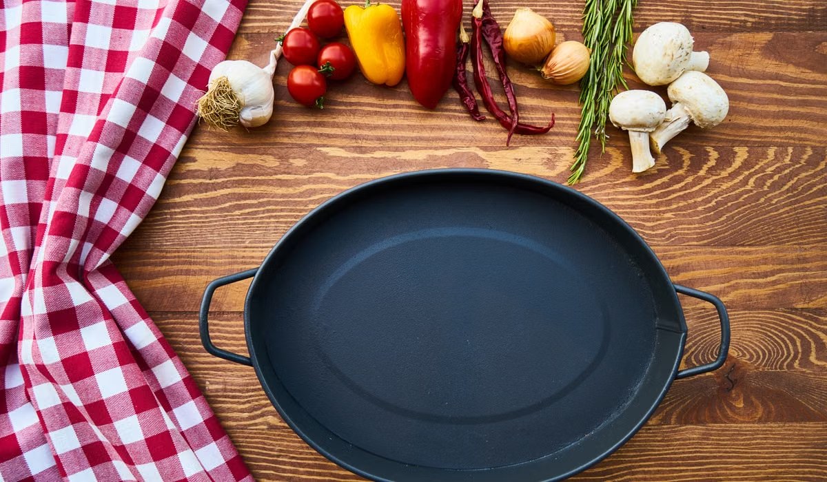 Cast iron skillet on a kitchen table with spices